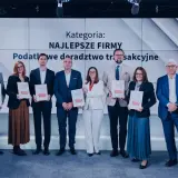 Grupa osób odbiera nagrody na tle ekranu z napisem "Kategoria: Najlepsze Firmy".